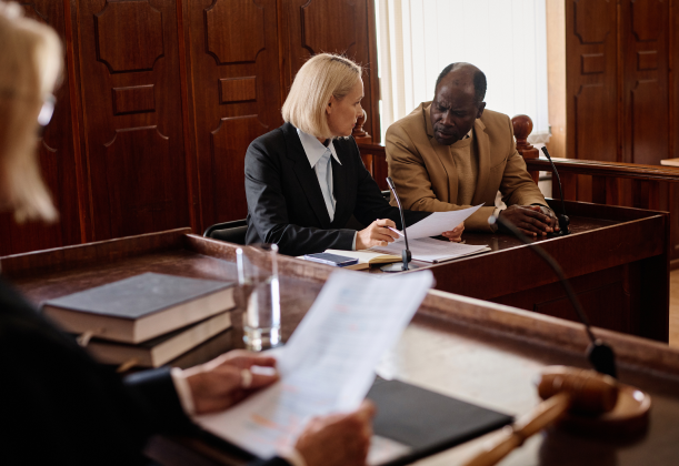 an attorney and defendant talking in a courtroom from the angle of a judge