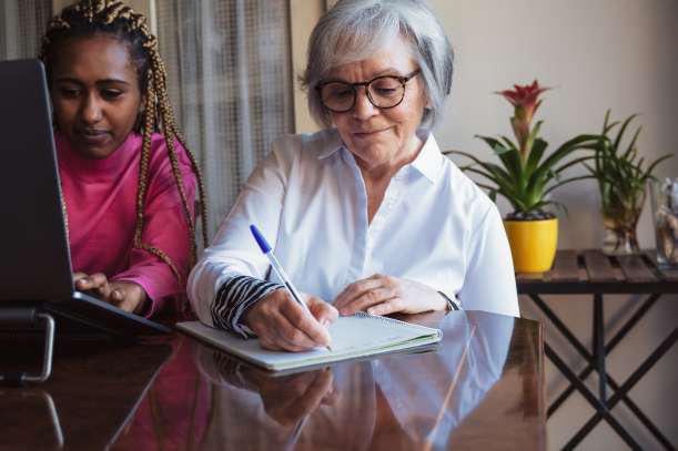 an old woman writing her will with an attorney sitting next to her