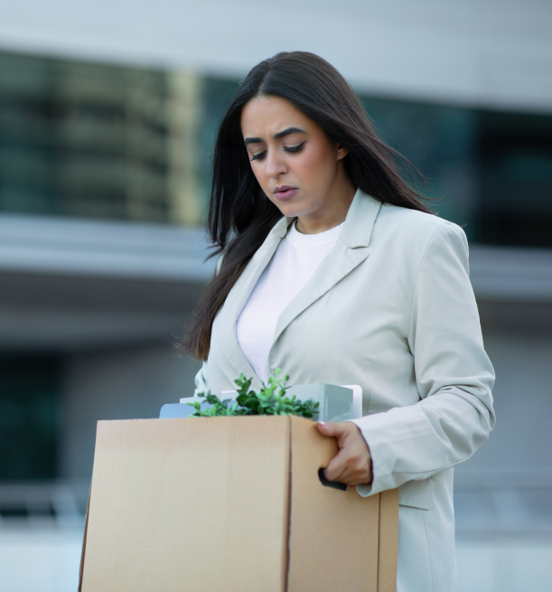 woman walking outside with a box of her stuff after she was wrongfully terminated